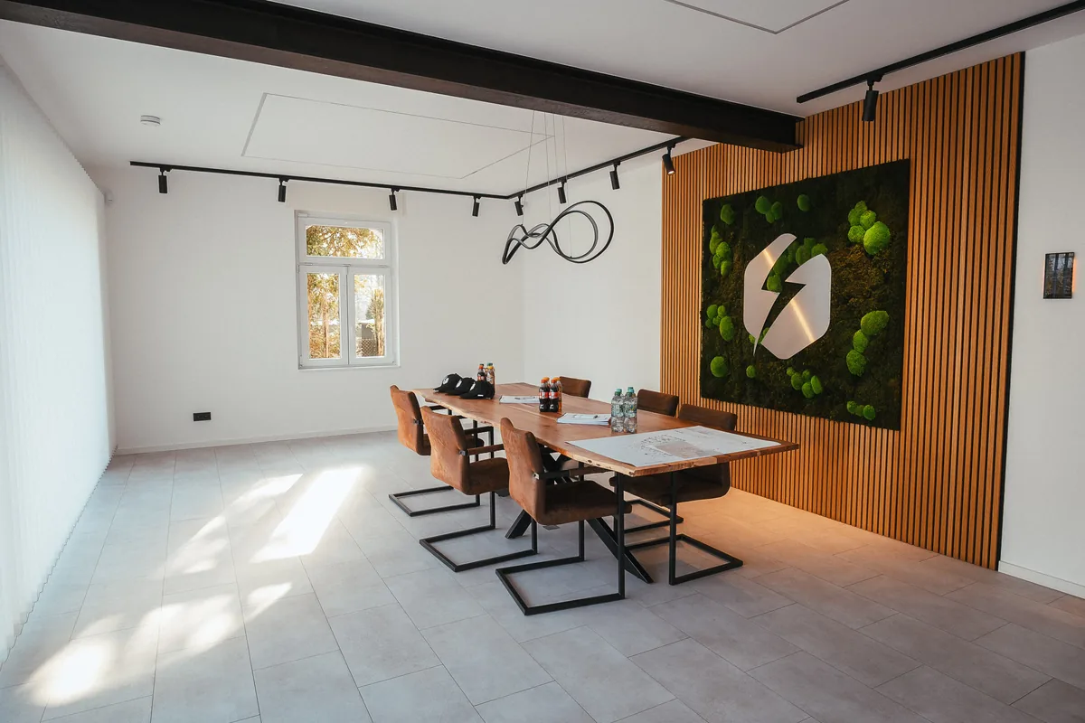 Besprechungsraum mit Mooswand und Kleber-Logo im neuen Büro
