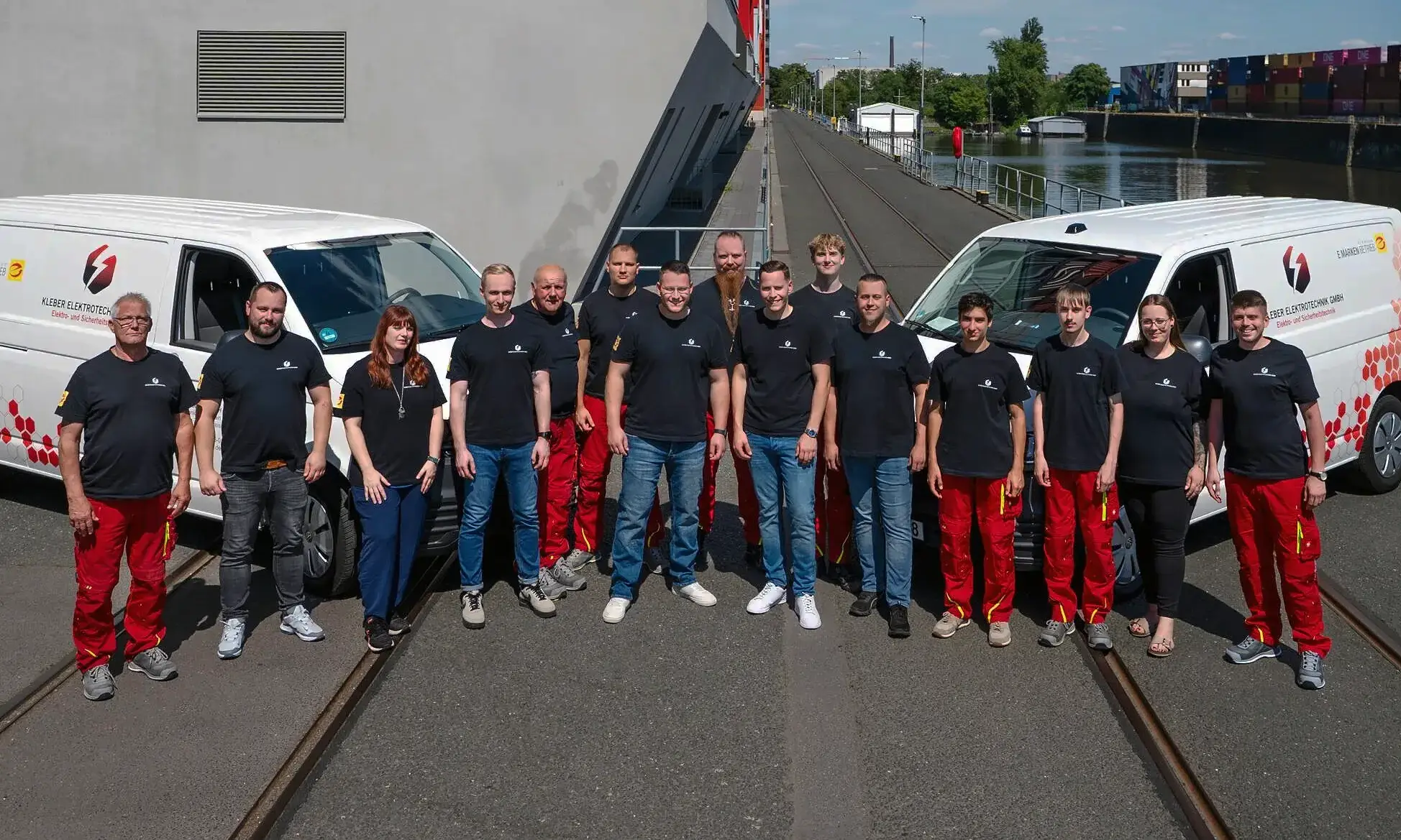 Das Team der Kleber Elektrotechnik vor den Firmenwagen
